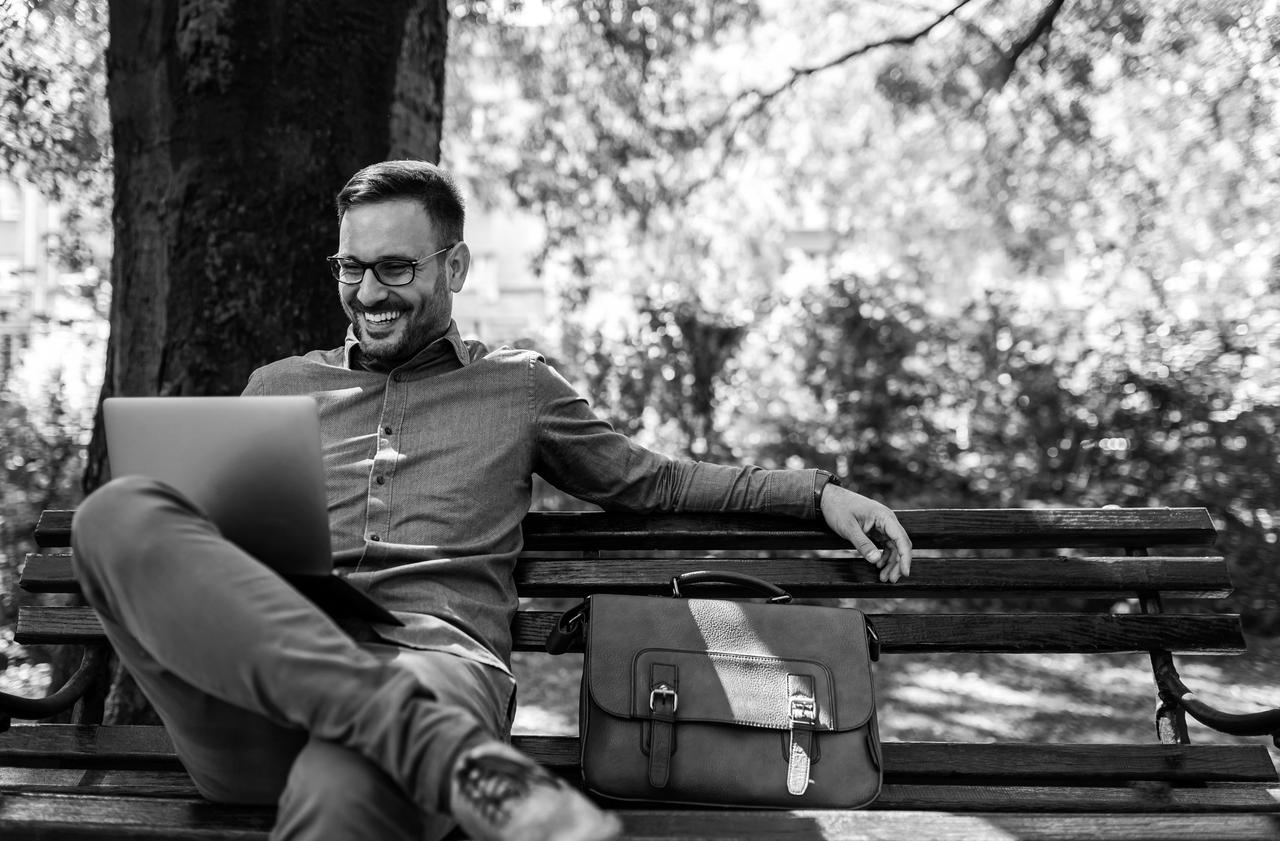 Man sitting cross-legged on bench in the park