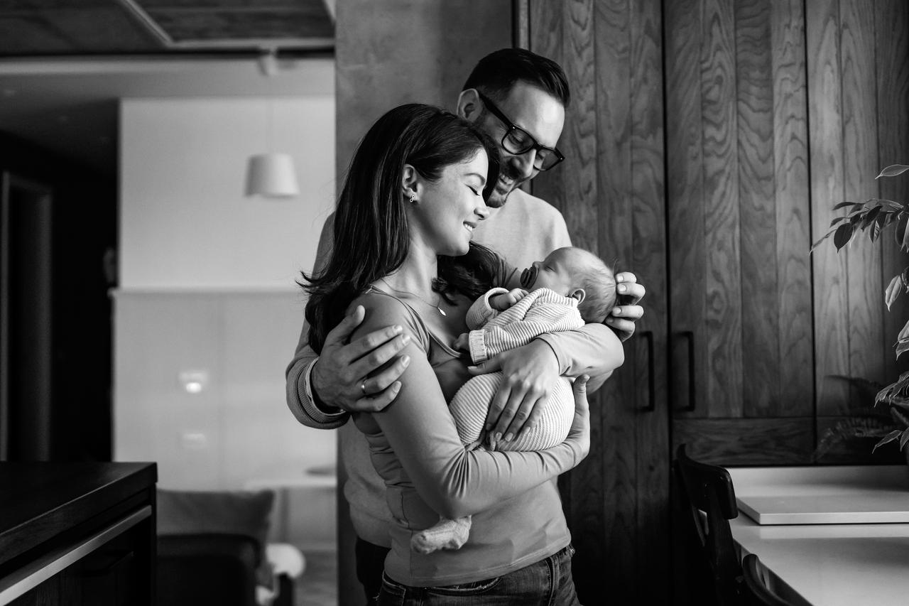 Happy young mother & father with new born baby at home