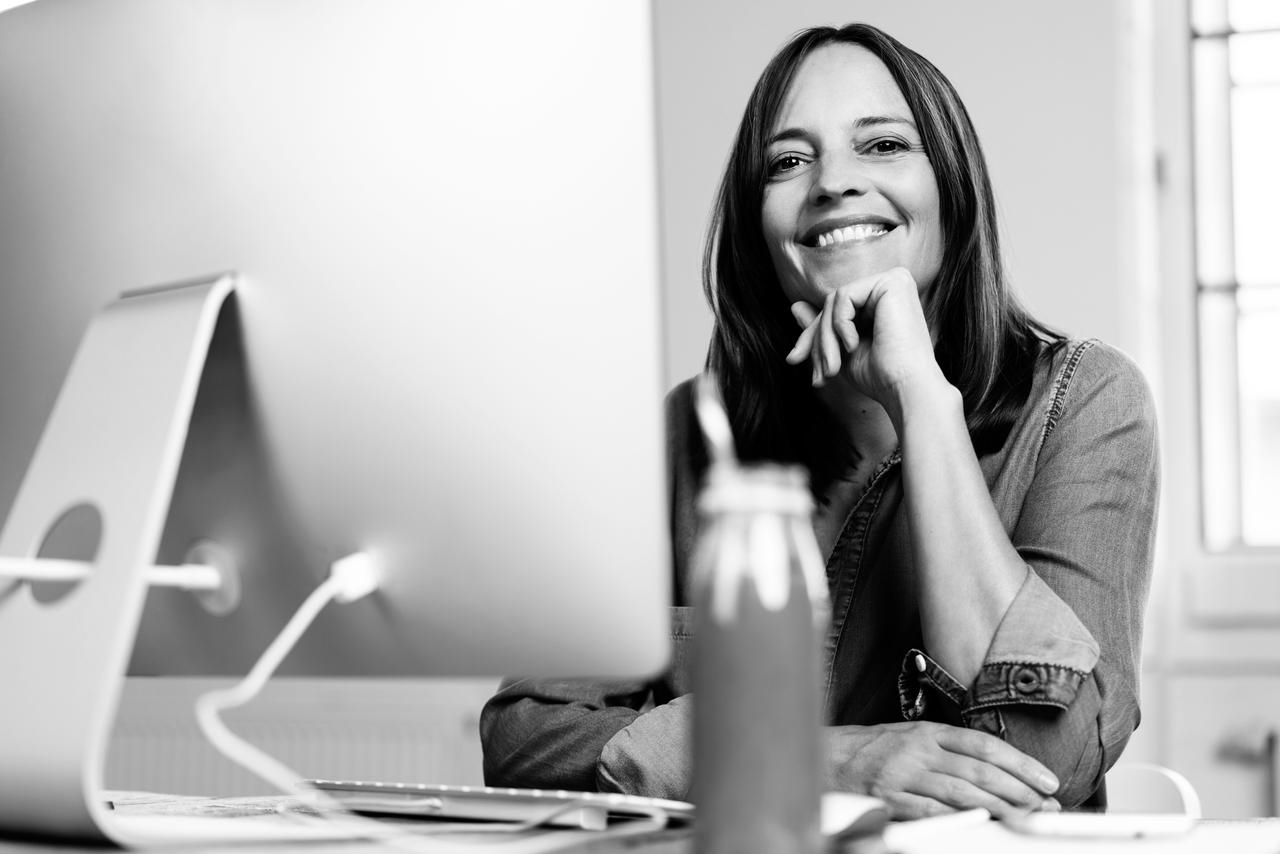 A woman smiling at a computer