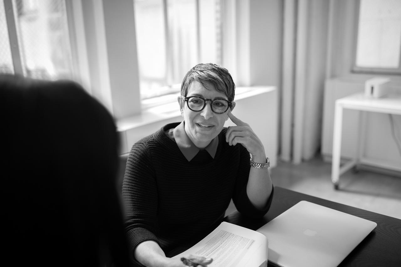 A woman sitting at a table with a book