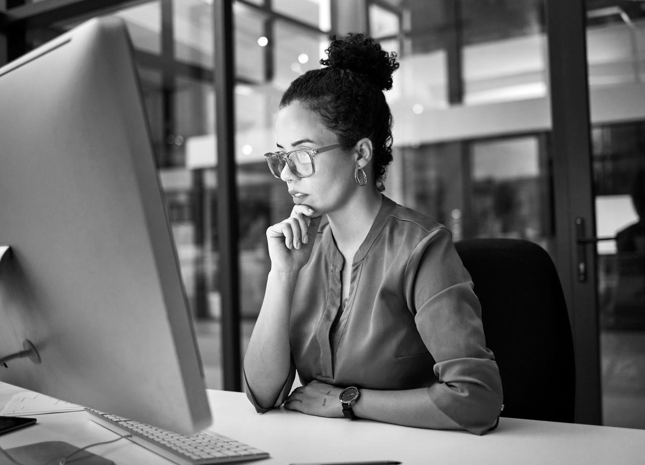 Young woman in front of computer monitor concentrating on a task