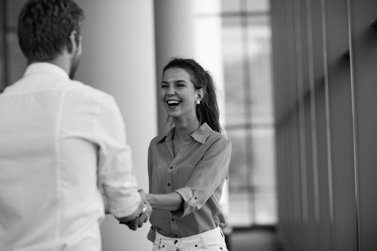 A young woman and man shaking hands